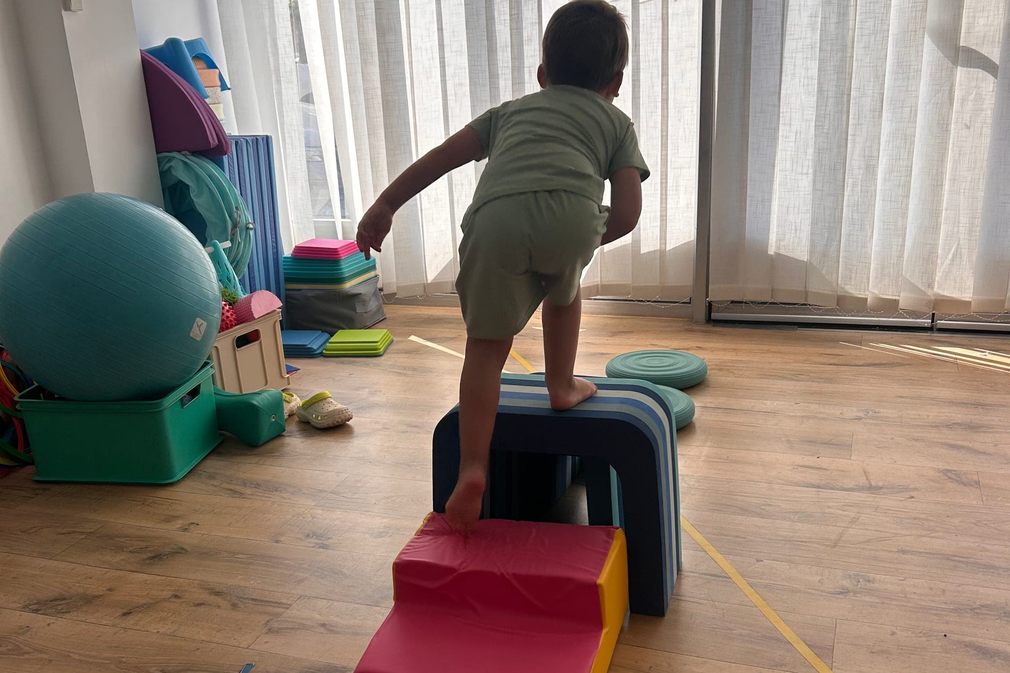 Un enfant, de dos, franchit un parcours moteur dans la salle du cabinet