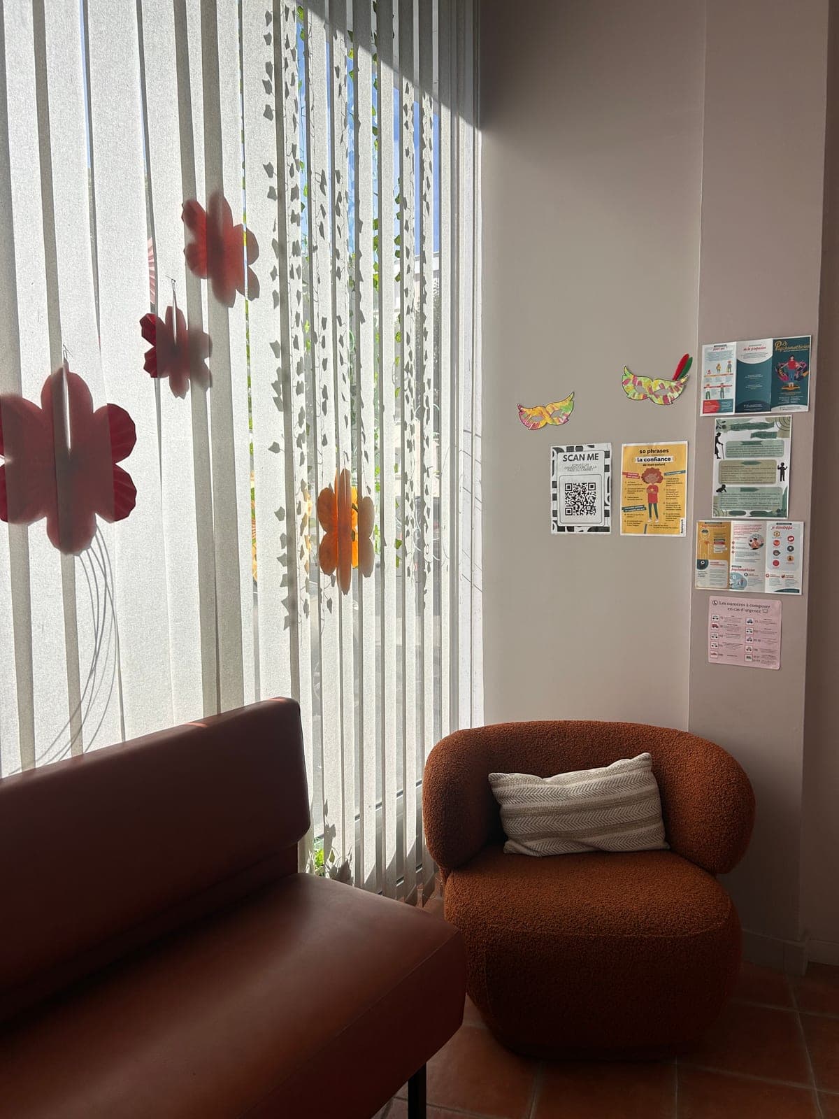 La salle d'attente, un canapé et un fauteuil près de la vitrine